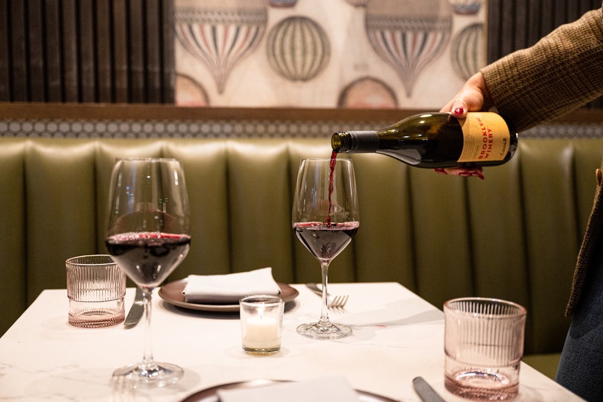 a bottle of wine glasses sitting on a table